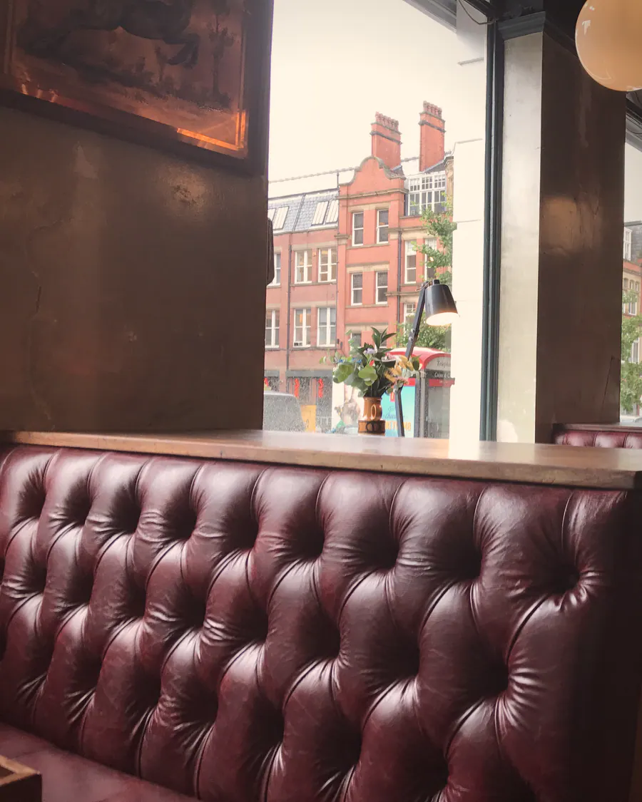 The oxblood buttoned-leather booths by the window at Flok